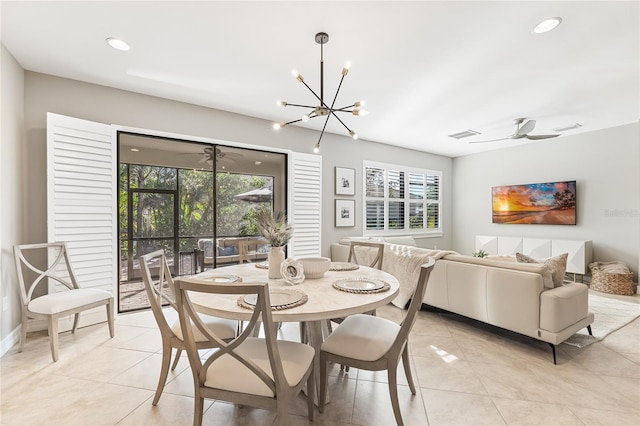 tiled dining room with ceiling fan with notable chandelier