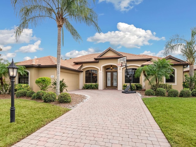 mediterranean / spanish-style house featuring french doors, a front lawn, and a garage