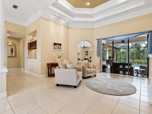 living room with crown molding, light tile patterned floors, and ceiling fan