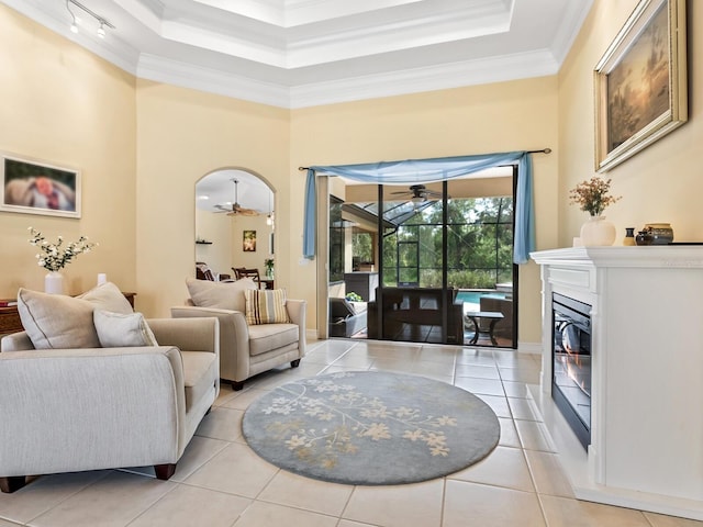 living room with light tile patterned floors, crown molding, and a high ceiling