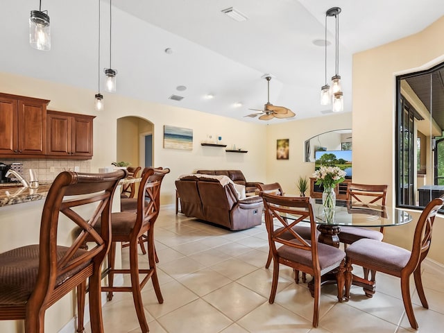 tiled dining room featuring ceiling fan and sink