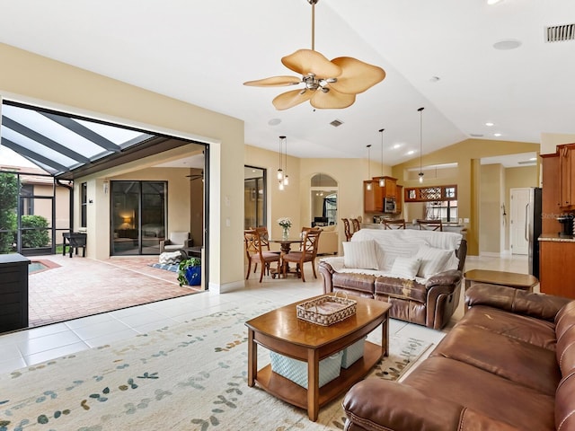 living room featuring ceiling fan, light tile patterned floors, and vaulted ceiling