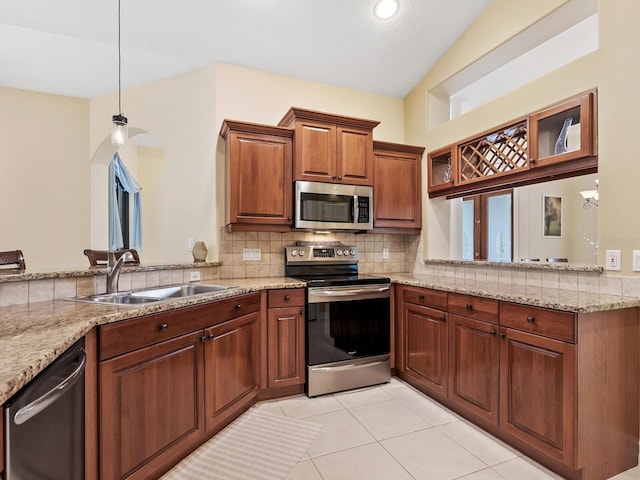 kitchen featuring sink, stainless steel appliances, kitchen peninsula, decorative light fixtures, and light tile patterned flooring