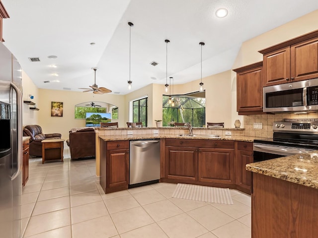 kitchen featuring kitchen peninsula, appliances with stainless steel finishes, hanging light fixtures, and sink