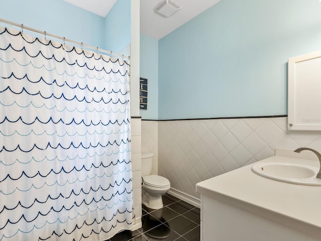 bathroom with vanity, tile patterned floors, toilet, tile walls, and walk in shower