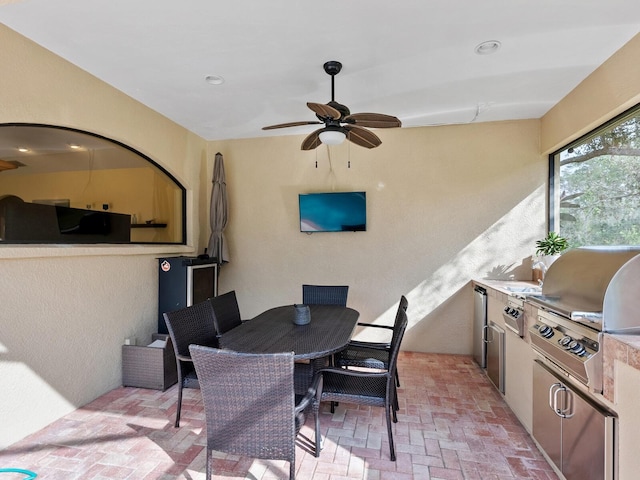 view of patio featuring a grill, ceiling fan, and an outdoor kitchen