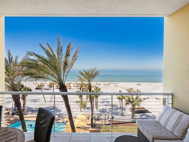 balcony featuring a beach view and a water view