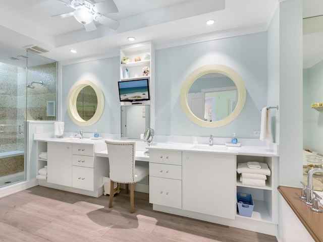 bathroom with ceiling fan, ornamental molding, wood-type flooring, a shower with door, and vanity