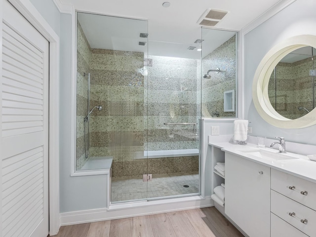 bathroom with a shower with door, vanity, and hardwood / wood-style floors