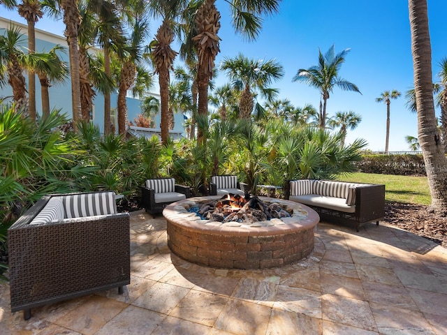 view of patio with an outdoor living space with a fire pit