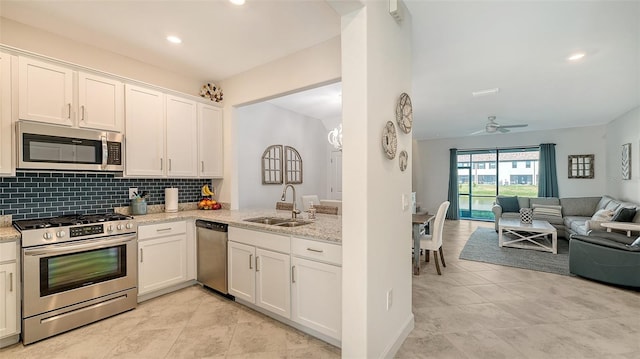 kitchen featuring light stone countertops, ceiling fan, sink, stainless steel appliances, and white cabinets