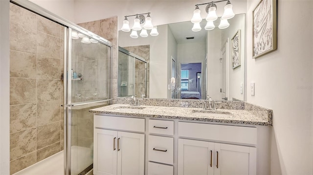 bathroom with vanity and a shower with door