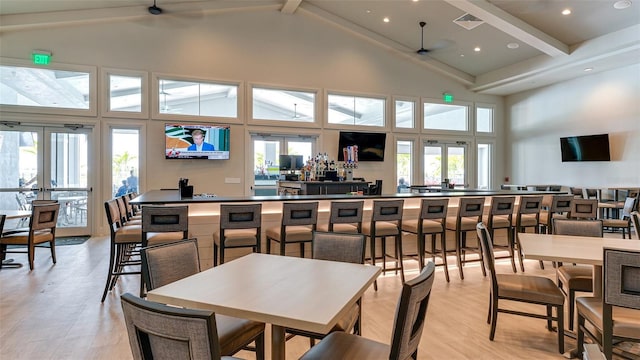 dining room with ceiling fan, beamed ceiling, high vaulted ceiling, and light hardwood / wood-style flooring