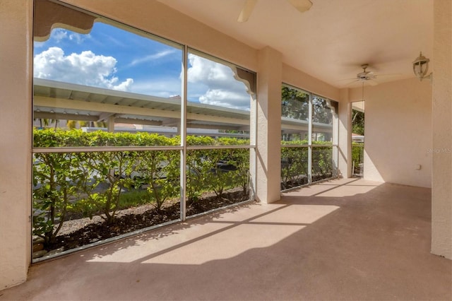 unfurnished sunroom with ceiling fan and plenty of natural light