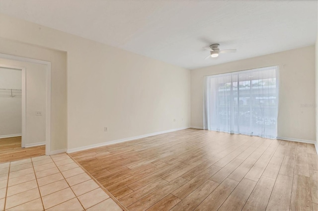 empty room with ceiling fan and light hardwood / wood-style flooring