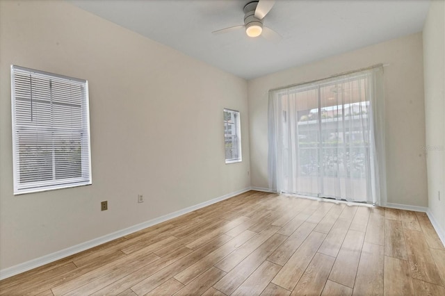 spare room with ceiling fan, a wealth of natural light, and light hardwood / wood-style flooring