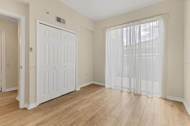 unfurnished bedroom featuring a closet and light wood-type flooring