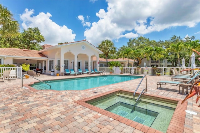 view of swimming pool with a patio area, ceiling fan, and a community hot tub