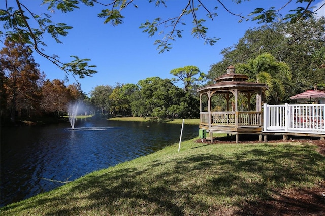 view of dock featuring a gazebo, a water view, and a yard