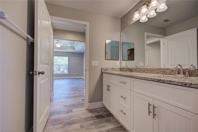 bathroom featuring hardwood / wood-style flooring, ceiling fan, a textured ceiling, and vanity