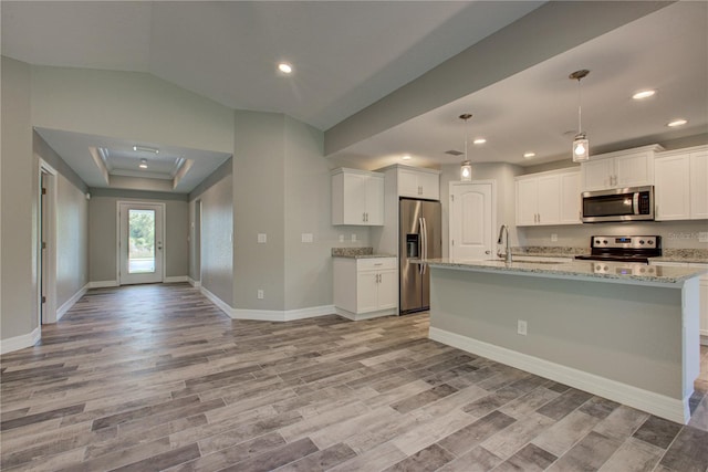 kitchen featuring appliances with stainless steel finishes, light hardwood / wood-style floors, white cabinetry, and decorative light fixtures