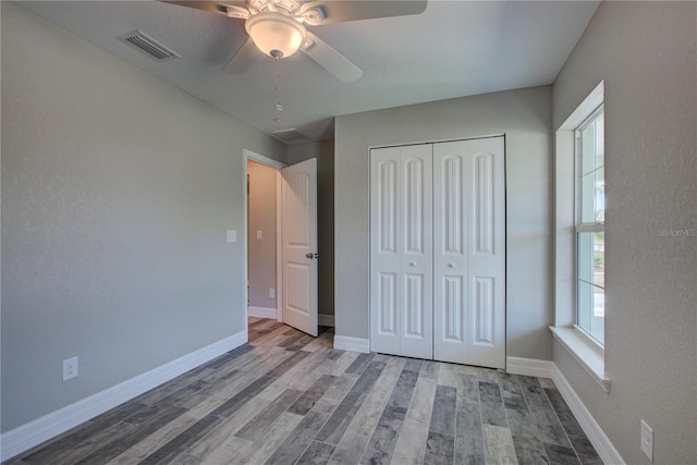 unfurnished bedroom featuring ceiling fan, wood-type flooring, and a closet