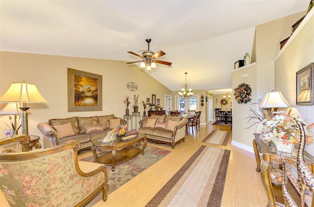 living room featuring ceiling fan with notable chandelier and vaulted ceiling