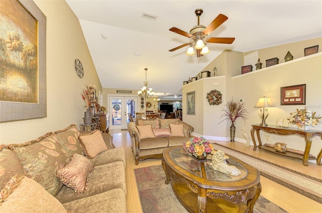 living room featuring french doors, ceiling fan with notable chandelier, wood-type flooring, and lofted ceiling