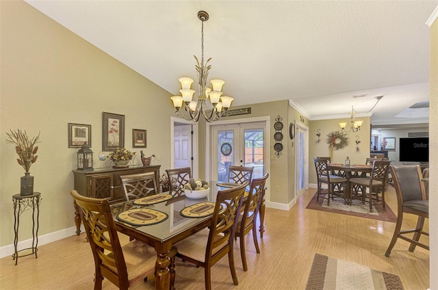 dining space featuring ornamental molding, light wood-type flooring, and a notable chandelier