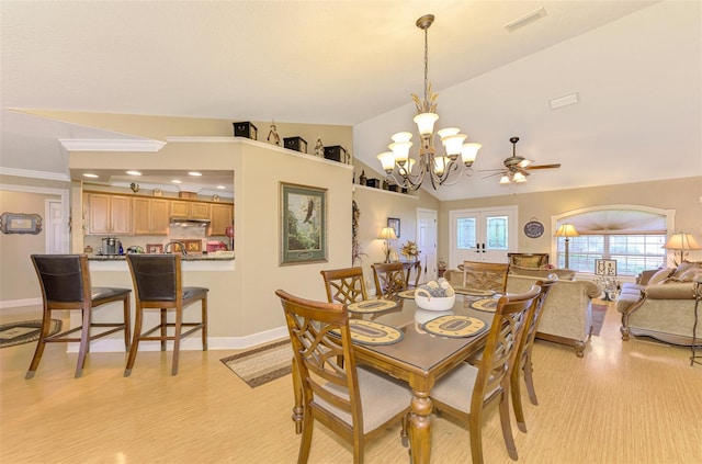 dining space featuring crown molding, light hardwood / wood-style flooring, ceiling fan with notable chandelier, and lofted ceiling