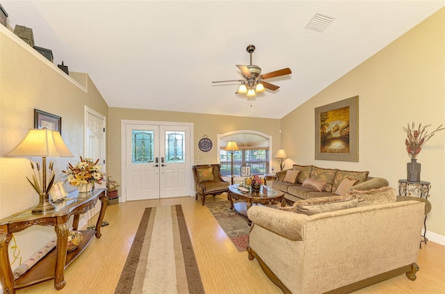 living room featuring french doors, light hardwood / wood-style flooring, vaulted ceiling, and ceiling fan