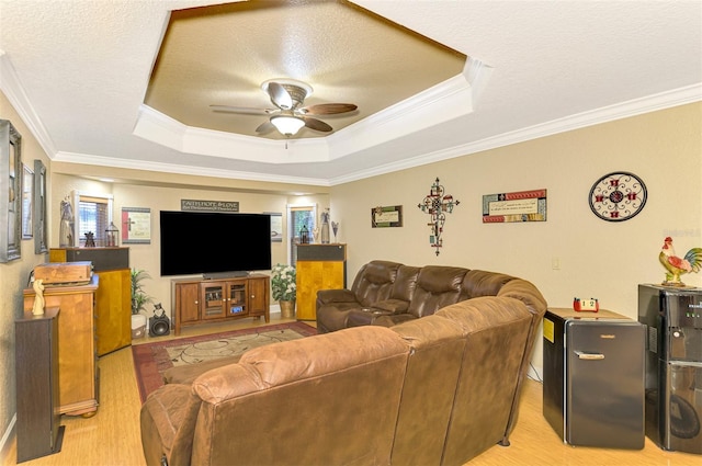 living room featuring a textured ceiling, ceiling fan, crown molding, and light hardwood / wood-style flooring