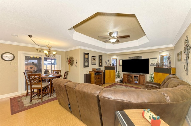 living room with ceiling fan with notable chandelier, a raised ceiling, crown molding, a textured ceiling, and light hardwood / wood-style floors