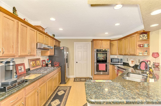 kitchen with sink, backsplash, light hardwood / wood-style floors, a textured ceiling, and appliances with stainless steel finishes