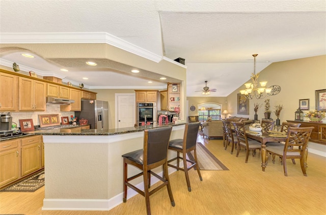 kitchen featuring a center island, light hardwood / wood-style flooring, stainless steel refrigerator with ice dispenser, a textured ceiling, and ceiling fan with notable chandelier