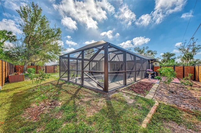 back of property featuring a yard, glass enclosure, a patio area, and a swimming pool