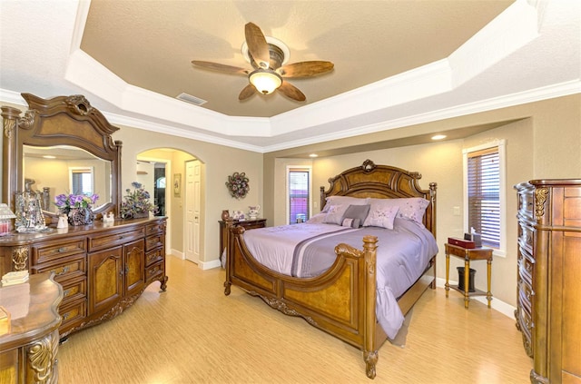 bedroom with a tray ceiling, crown molding, and ceiling fan