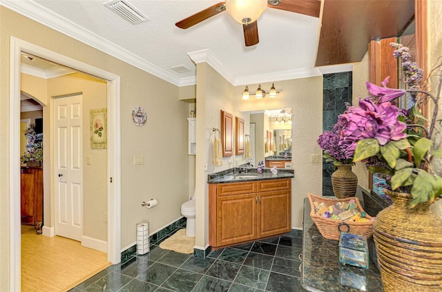 bathroom with vanity, hardwood / wood-style flooring, ceiling fan, toilet, and ornamental molding