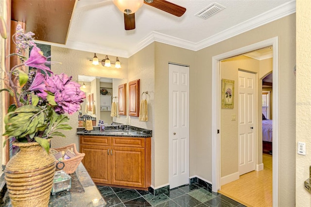 bathroom with ceiling fan, ornamental molding, a textured ceiling, vanity, and hardwood / wood-style flooring