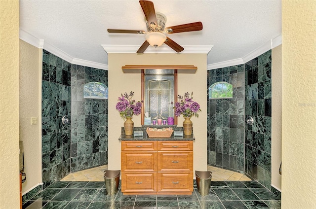 bathroom featuring ceiling fan, crown molding, vanity, and tiled shower