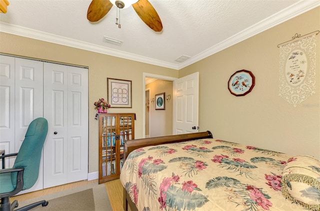 bedroom featuring a textured ceiling, a closet, ceiling fan, and ornamental molding