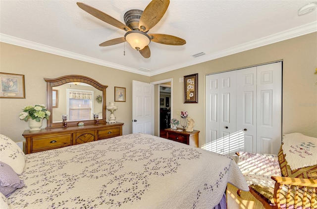 bedroom with ceiling fan, ornamental molding, a textured ceiling, and a closet