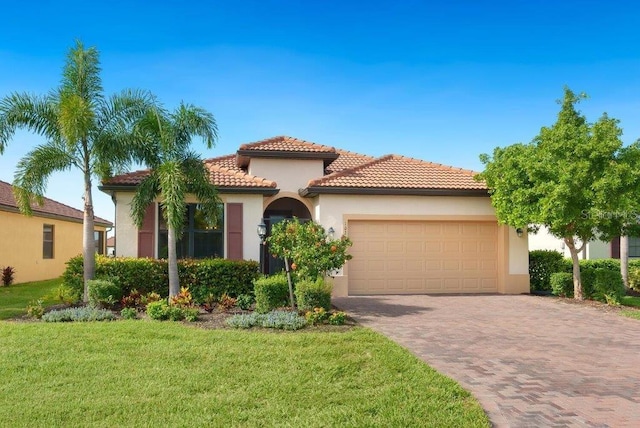 mediterranean / spanish-style home with a garage and a front lawn