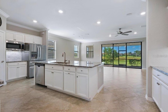 kitchen featuring stone counters, sink, a kitchen island with sink, white cabinets, and appliances with stainless steel finishes