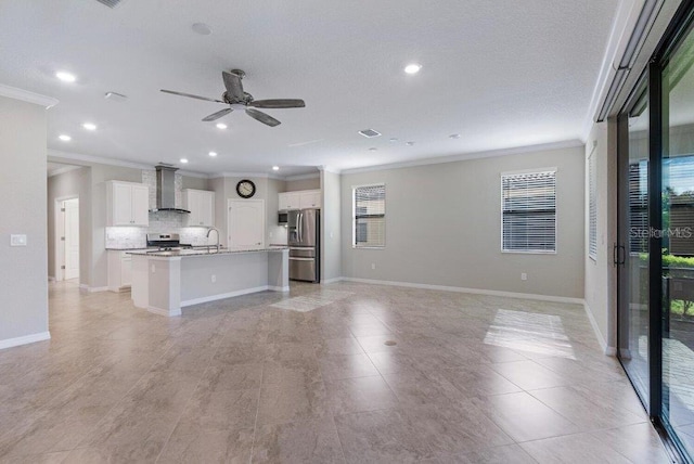 unfurnished living room with ceiling fan, sink, light wood-type flooring, and crown molding