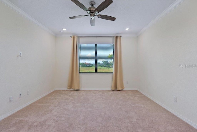 spare room featuring ceiling fan, light colored carpet, and ornamental molding