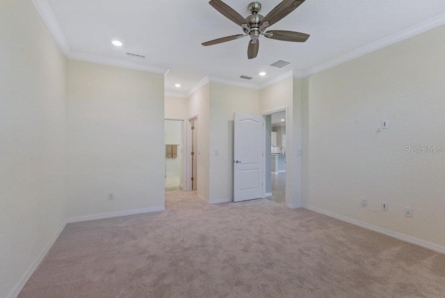 unfurnished bedroom featuring ceiling fan, light colored carpet, and crown molding