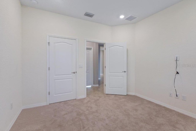 spare room featuring light colored carpet