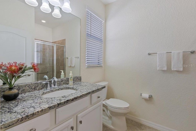 bathroom with tile patterned flooring, vanity, a shower with shower door, and toilet