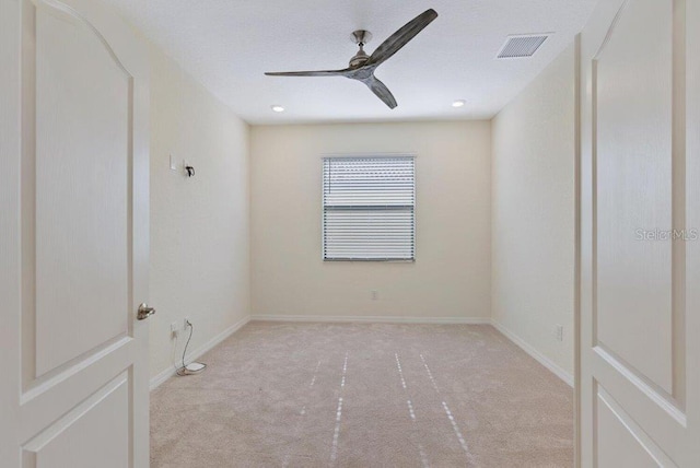 carpeted spare room featuring ceiling fan